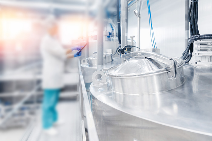 Dairy factory production, engineer operator check quality with computer tablet in milk tank